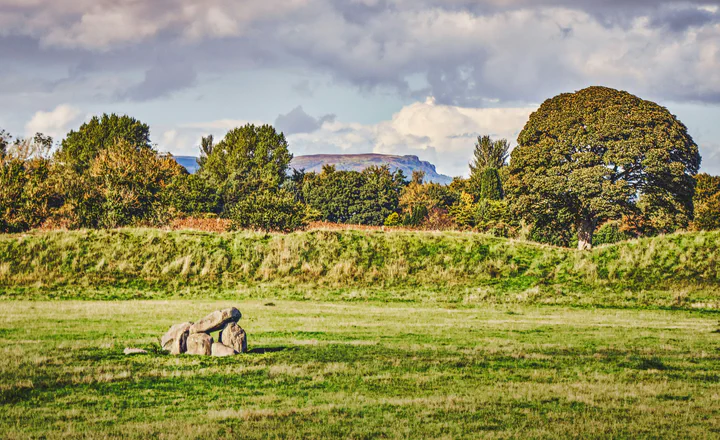 A stone monument in a green landscape; illustrative scenery, not a site identified with Niall.